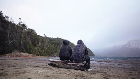 gesture of support between traveling friends on patagonian lake, emotional connection, argentina