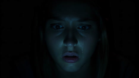 Young Woman&#039;s Shocked Reaction to a Screen in the Dark