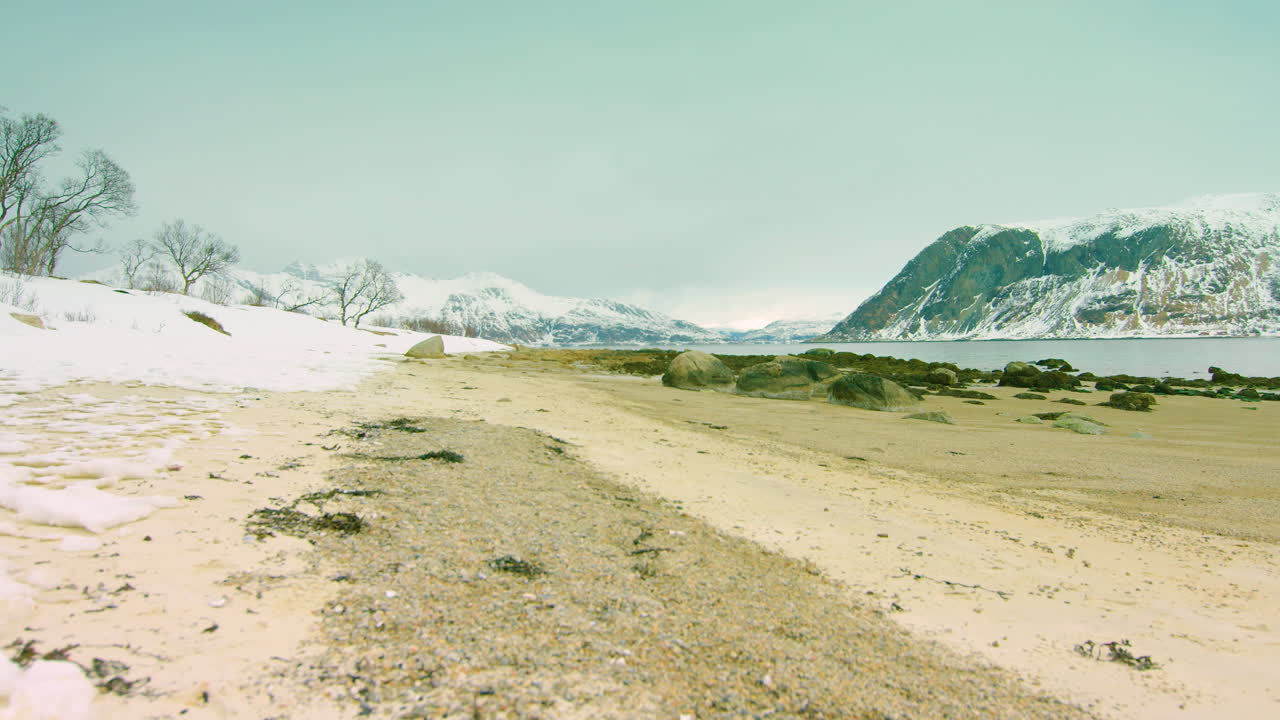 travelling cinematográfico en una playa nevada en un fiordo