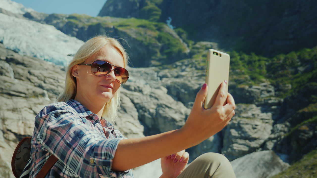 un turista feliz se hace selfie en el fondo de un glaciar en noruega viajando en concepto de noruega