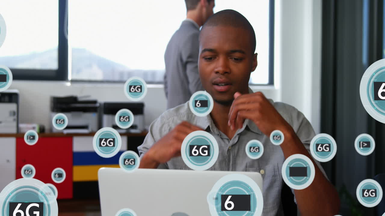 Animation of 5g and 6g text with symbols over thoughtful african american man working on laptop