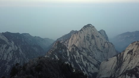 rising aerial reveals buildings perched on dramatic granite summit