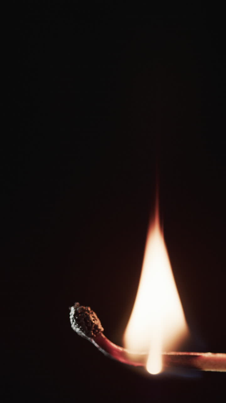 Vertical video of lit alcohol flames and copy space on black background