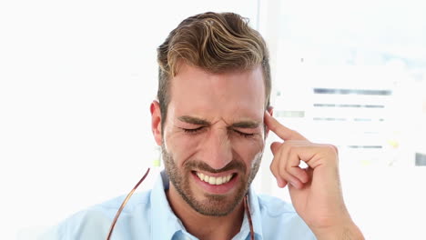 Businessman-with-a-headache-taking-off-his-glasses-