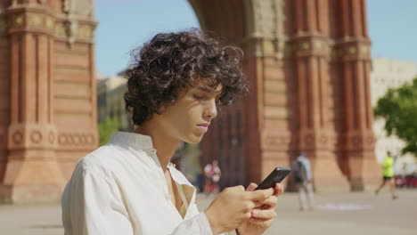 Porträt-Eines-Jungen-Mannes,-Der-Auf-Einer-Städtischen-Straße-Sein-Mobiltelefon-Sucht