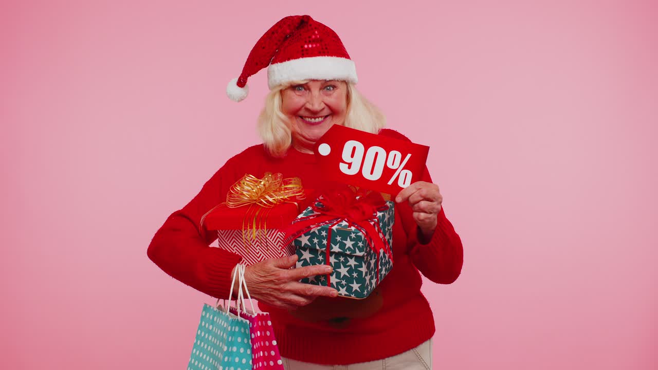 mujer mayor en suéter de navidad mostrando caja de regalos y 90 por ciento de descuento inscripciones texto de pancarta