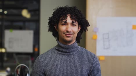 portrait of happy biracial businessman looking at camera at office