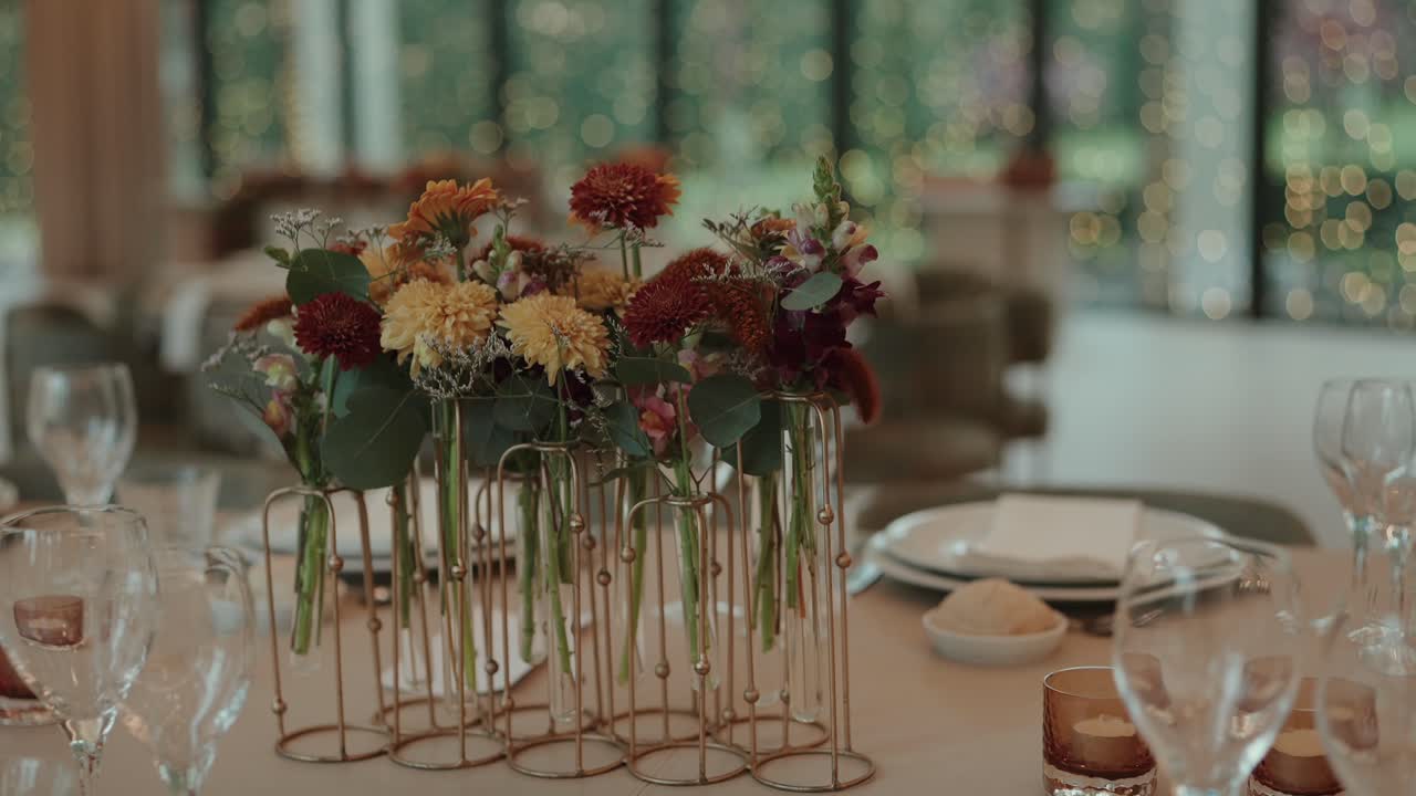 Blomstermidtdel til bord med glassplater og lys innendørs