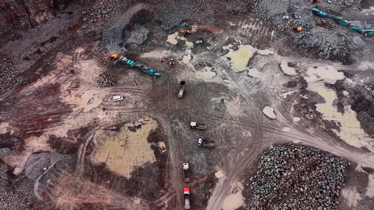 Activity at granite quarry site with vehicles and machinery in use