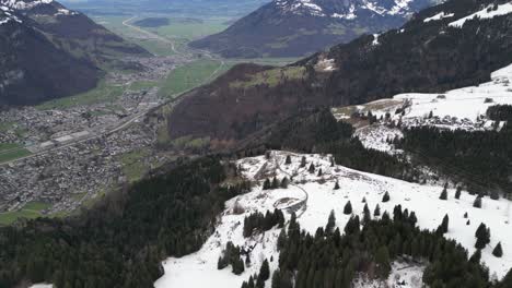 Fronalpstock-Glarus-Switzerland-aerial-high-and-wide-above-mountains-and-village-below