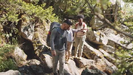 multiethnic family walking on rocky trail during hike