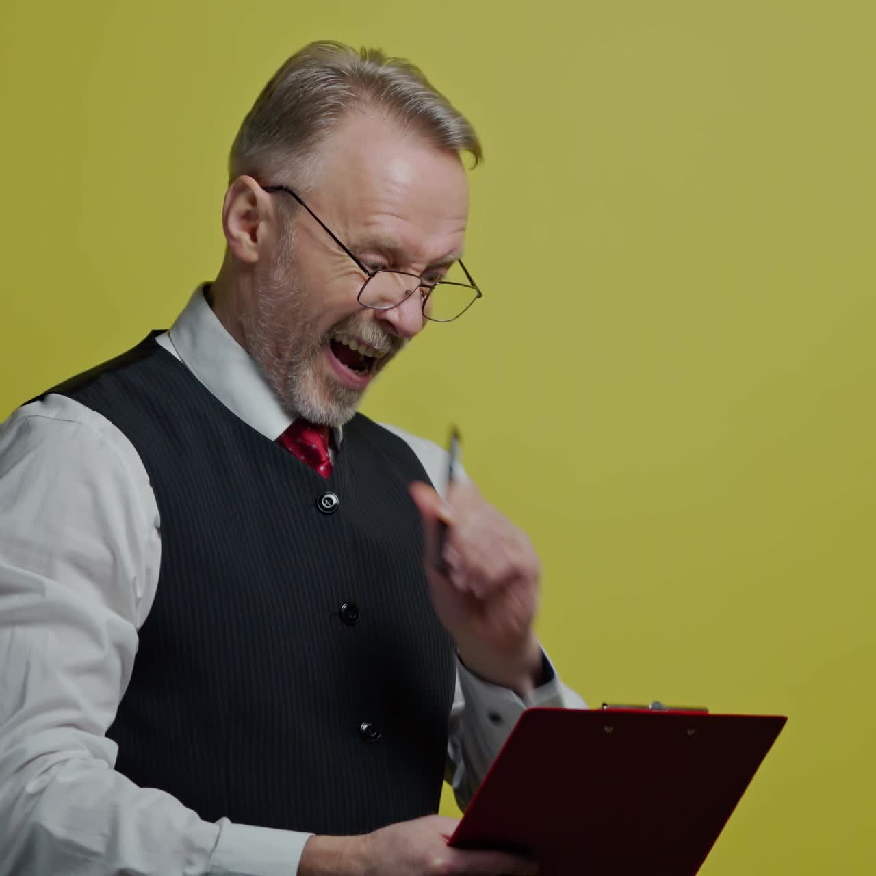 Portrait of serious grey-haired man with a folder. Senior man in glasses in suit writing on a folder. Old man expresses different facial emotions on yellow background.