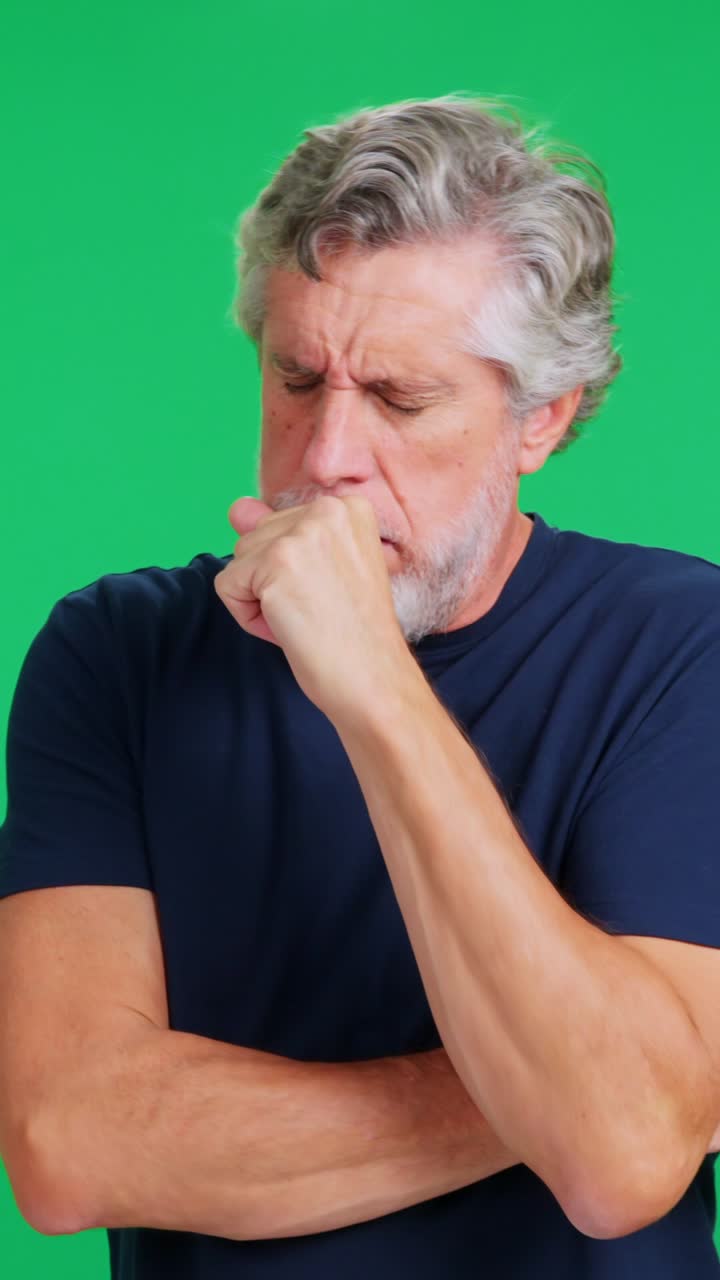 Uomo maturo che tossisce e si sente male su sfondo verde