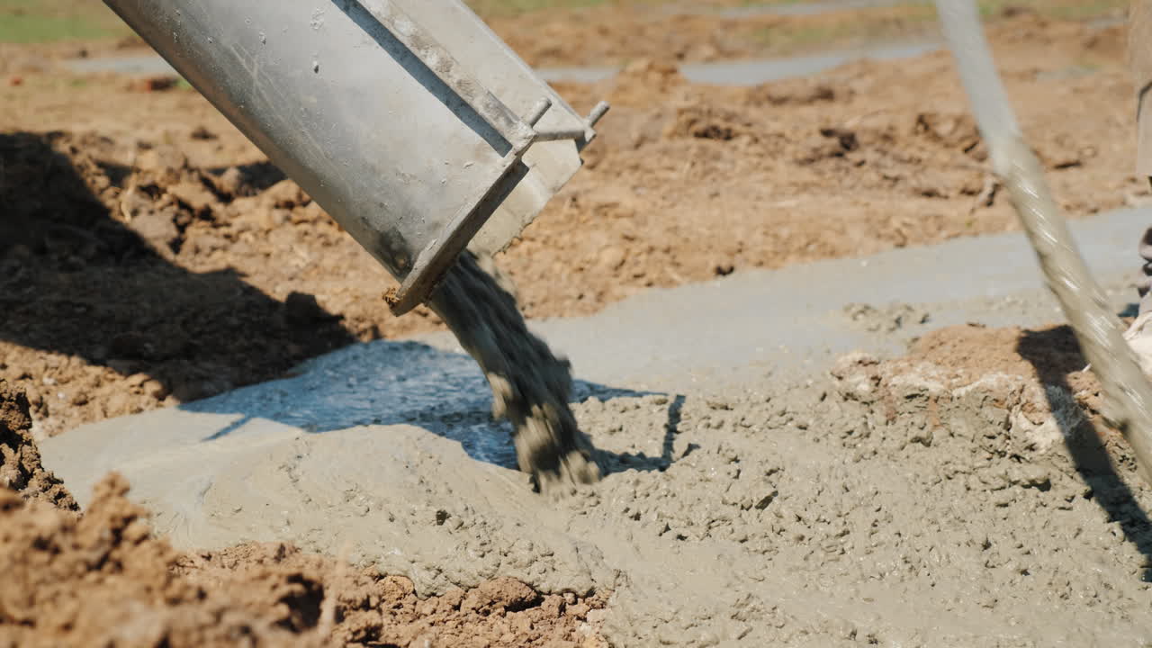 el hormigón fluye a través de la tubería hacia los cimientos del concepto de construcción de cabañas en el sótano