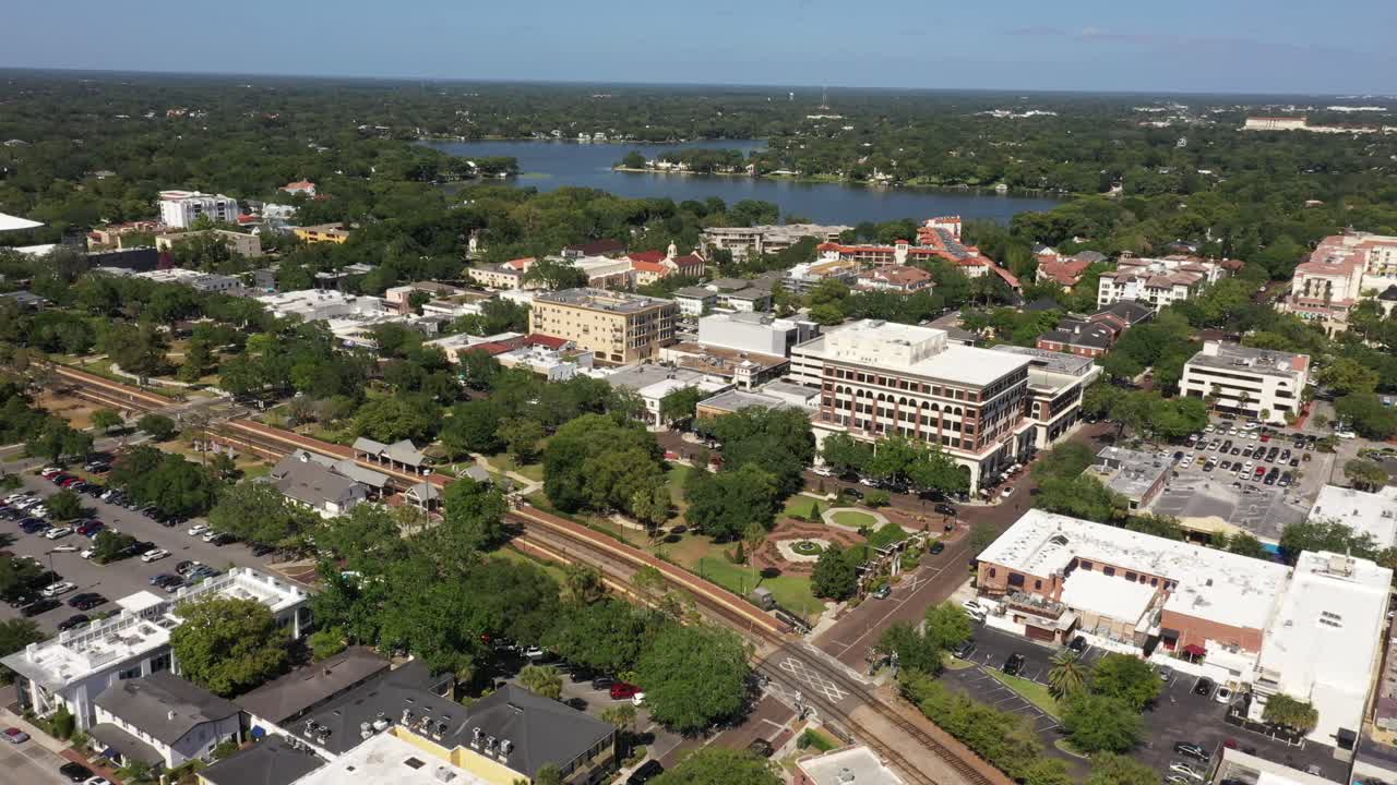 Aerial tilted angle overview of Winter Park with dense city layout and green tree canopies, Florida
