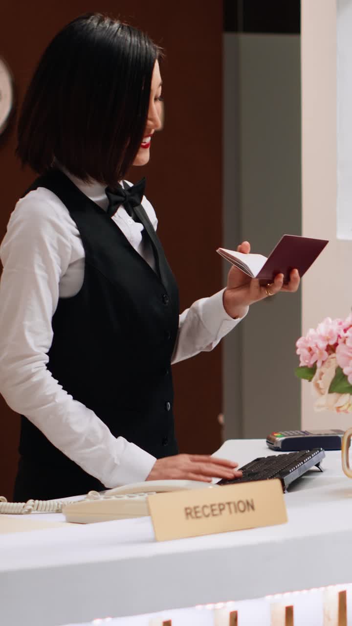 Employé d’hôtel regardant un passeport en format vertical pour l’enregistrement