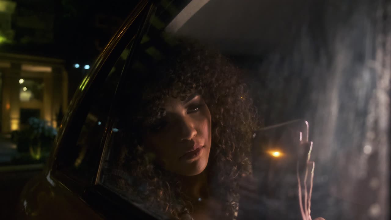 Woman with curly hair in car at night