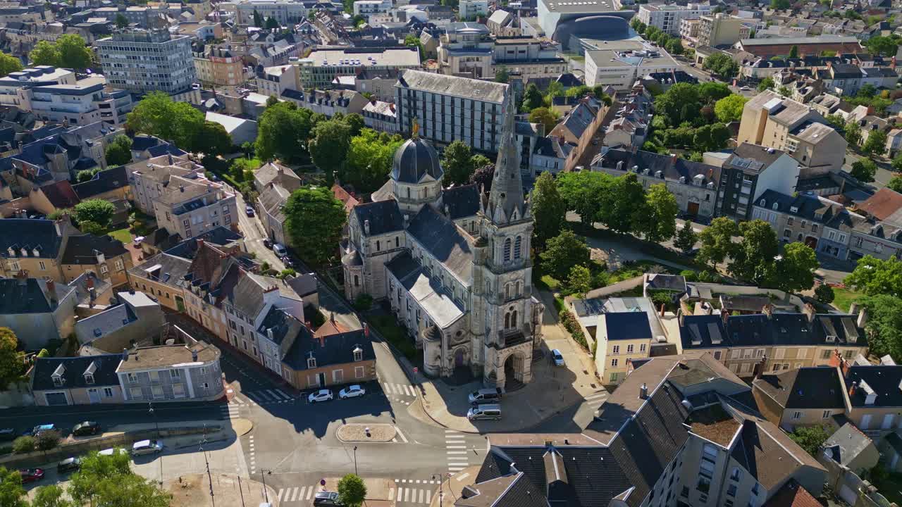 Aerial approach to Eglise Notre Dame de Chateauroux surrounded by buildings in city center, France