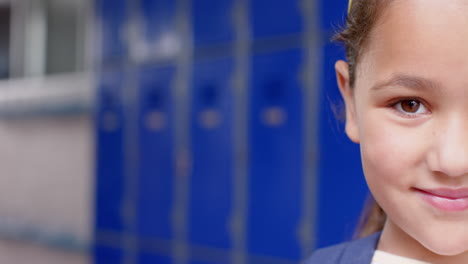 smiling girl in school uniform standing in front of blue lockers, copy space