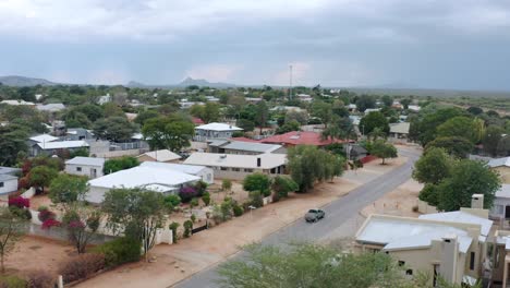 Luftaufnahme,-Die-Einem-Lastwagen-Folgt,-Der-Durch-Eine-Kleine-Stadt-Im-Ländlichen-Afrika-Fährt