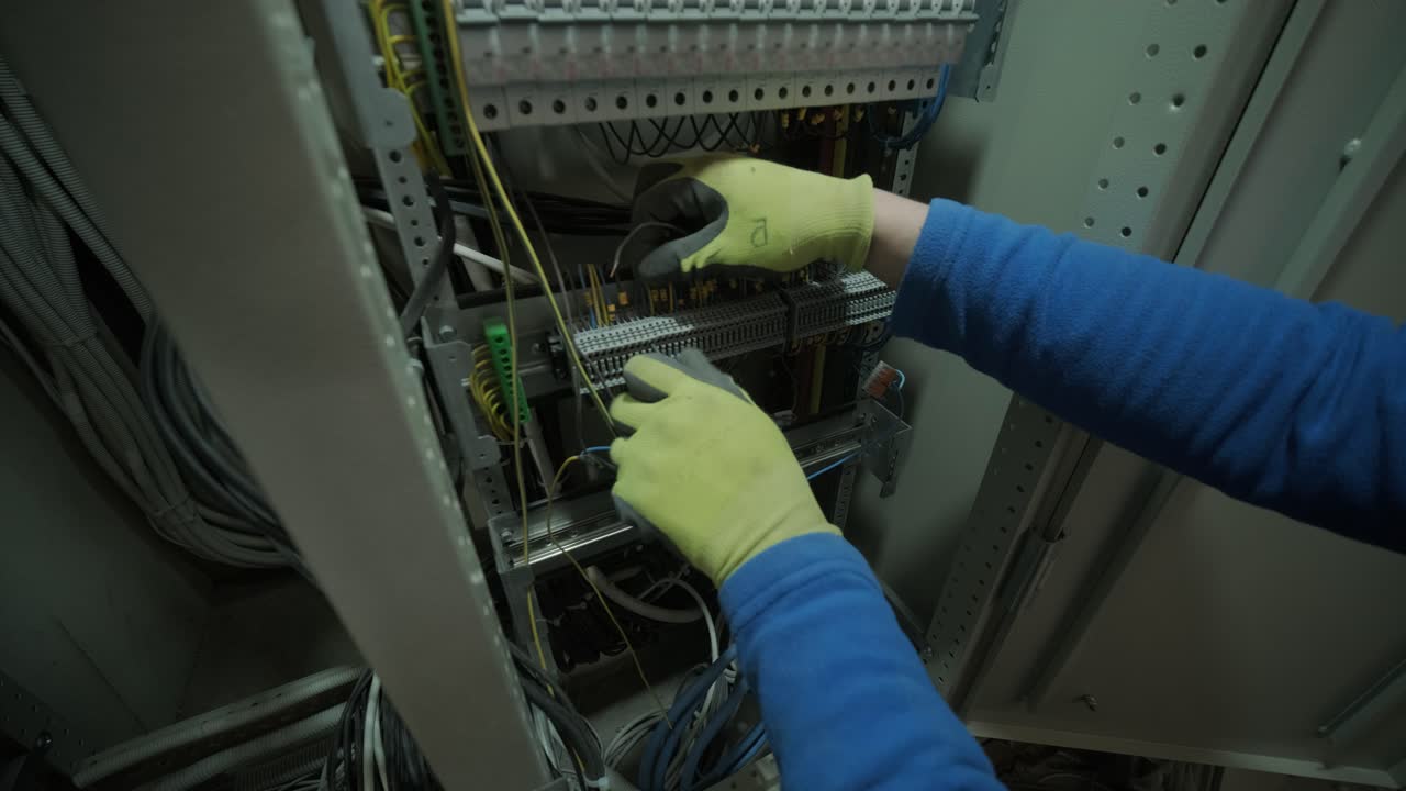 electricista trabajando en interruptores dentro del panel de control