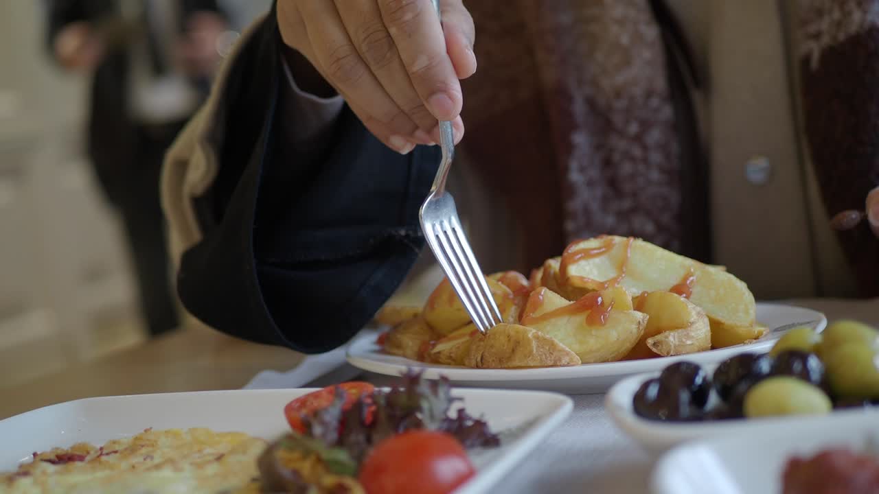 Close-up of a meal featuring potatoes, omelet, and olives