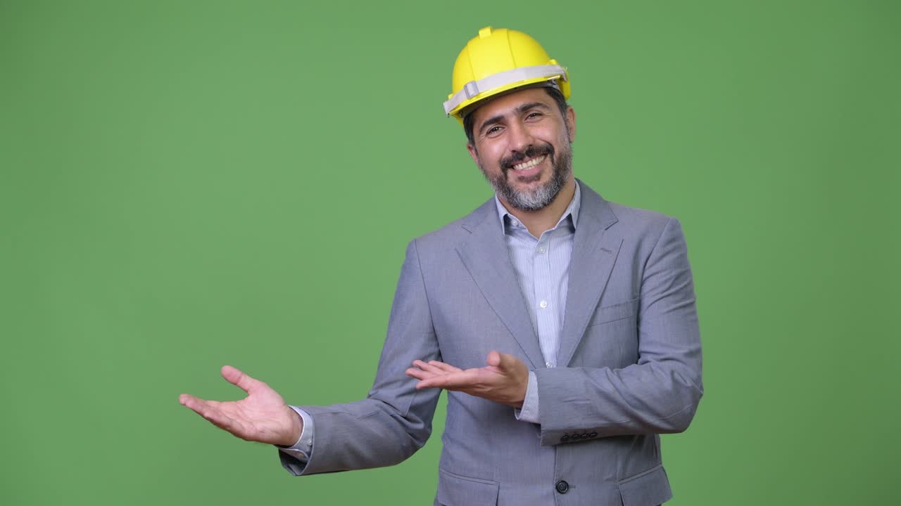 Handsome Persian bearded businessman as engineer showing something