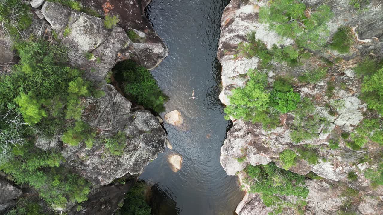 turista femenina flotando en un aislado pozo de agua del interior de australia
