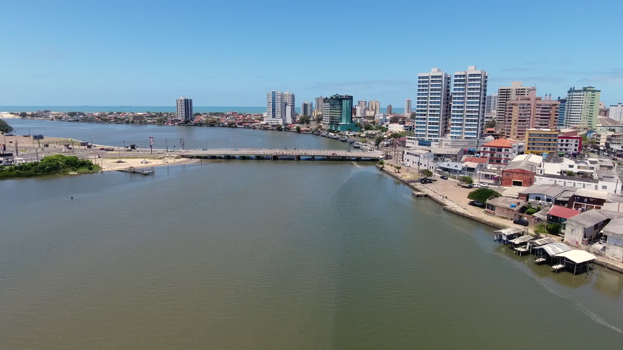 Veduta aerea che si avvicina al ponte tra Imbé e Tramandaí con lungomare urbano e sfondo oceanico nel Brasile meridionale