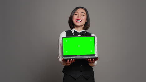 Asiatischer-Hotel-Concierge-Hält-PC-Mit-Greenscreen-Vor-Der-Kamera