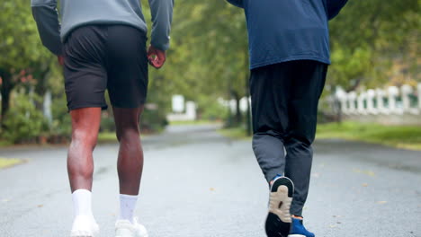 two men running in a park on a rainy day