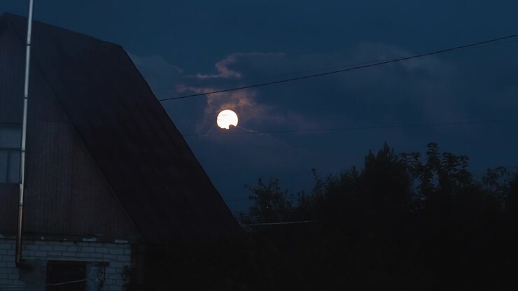 Luna piena luminosa che risplende attraverso nuvole scure di notte