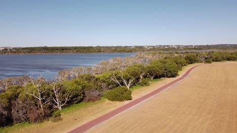 push forward aerial shot of the waters of lake joondalup and trees below