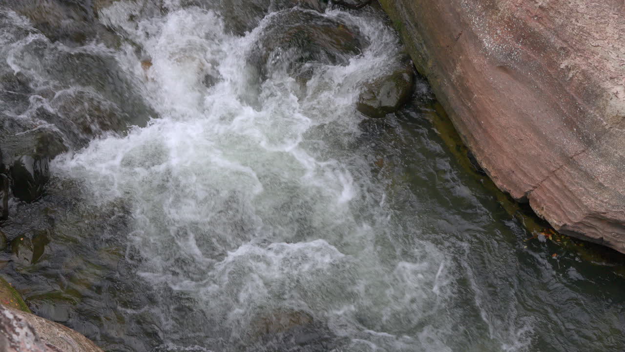 Rushing water flows over rocks in Cajones de Chame, Panama, nature's serenity captured