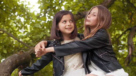 two happy sisters hugging outdoors