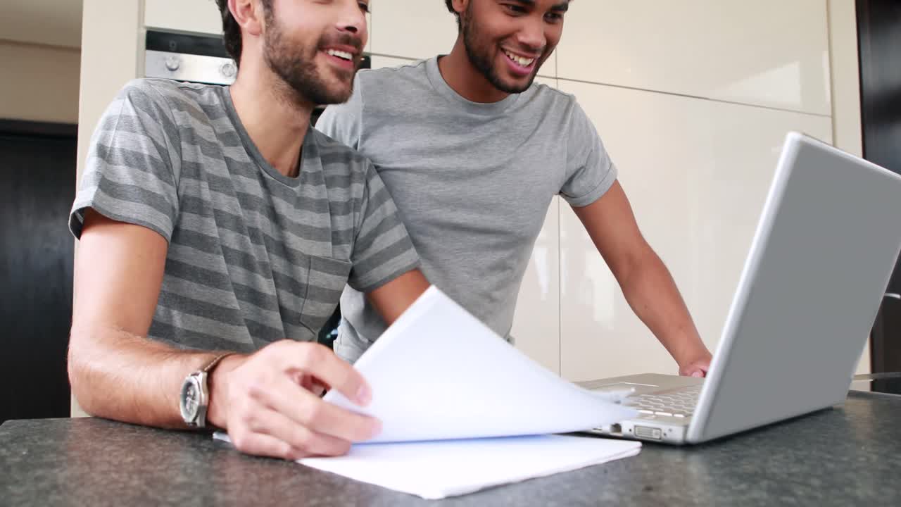 Happy homosexual couple using computer