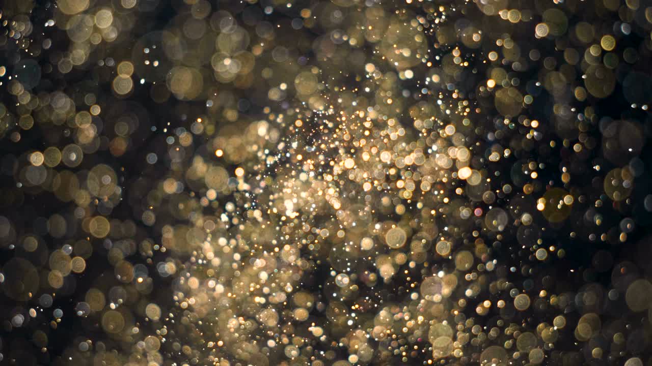 elegantes, detalladas y doradas partículas fluyen con poca profundidad de campo bajo el agua