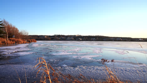 Pan-shot-of-a-frozen-lake-in-winter-by-sunset