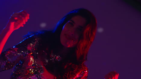 close up of woman in nightclub bar or disco dancing with sparkling lights 12