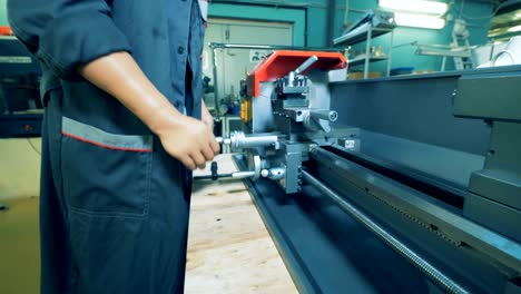 close up of a metal lathe regulated by a factory worker with prosthetic hands