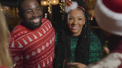 tracking shot around a small group of friends celebrating christmas at a bar