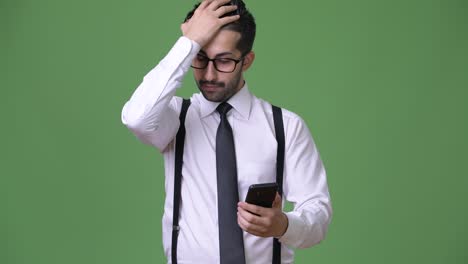 young handsome bearded persian businessman against green background