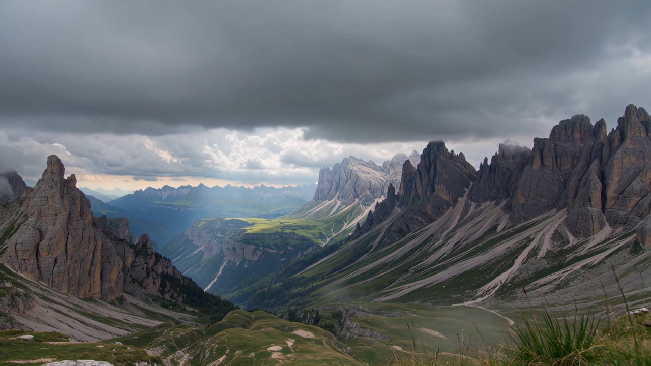 Nuvole temporalesche scure si muovono attraverso le spettacolari Dolomiti mentre la luce del sole filtra tra le nuvole e illumina le valli alpine e le cime calcaree