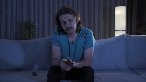 hombre nerd e introvertido pensativo en casa por la noche.