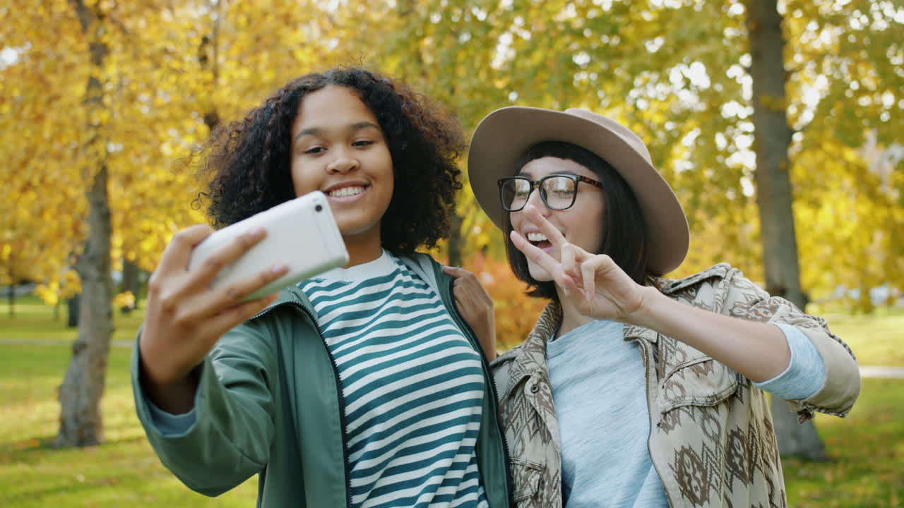 Two Friends Taking a Selfie in an Autumn Park