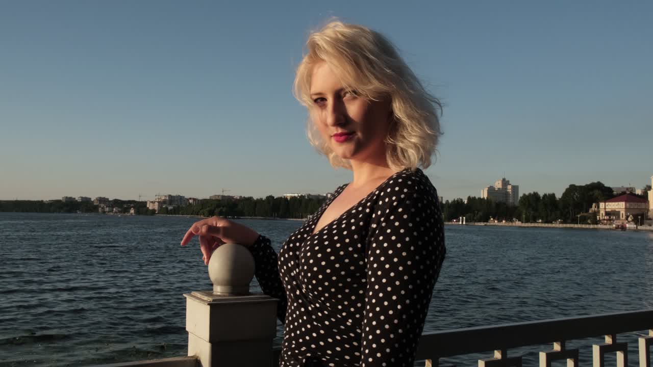 блондинка позирует на набережной