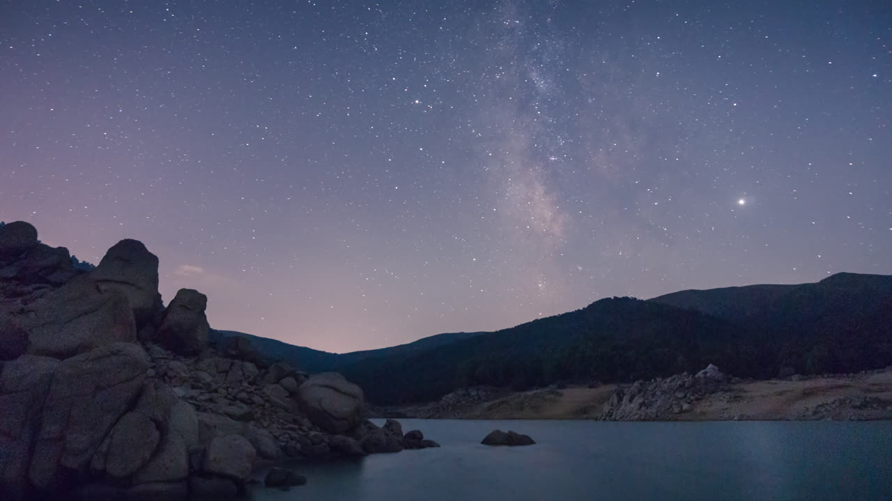 timelapse da via láctea sobre um lago