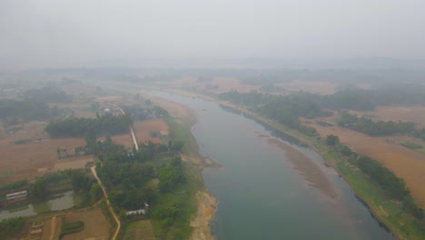 flying through thick morning fog over surma river in bangladesh
