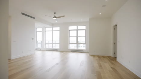 A bright and empty room with hardwood floors and white walls