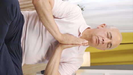 Vertical-video-of-Od-man-in-meditation-in-front-of-the-window.